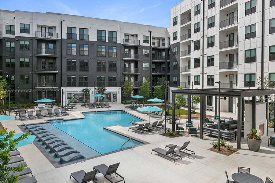 Piscina de agua salada inspirada en un resort con solárium y zonas de parrilla - Auden Apartments