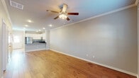 Located at 1059 Wisteria Ln in Springdale, Arkansas, this two-story home offers a well-organized layout across two levels, blending functional design with comfortable finishes throughout.

The main level features an open-concept living area with warm hardwood flooring, crown molding, recessed lighting, and a ceiling fan. This space flows seamlessly into a well-appointed kitchen equipped with white shaker-style cabinetry, dark granite countertops, stainless steel appliances, and a kitchen island with a brushed gold sink fixture. Large tile flooring grounds the kitchen area, and crown molding carries through for a cohesive, polished look.

A staircase with a white-trimmed banister and handrail connects the main level to the upper floor, where carpeted bedrooms provide a softer, quieter environment. Each bedroom includes ceiling fans and neutral-toned walls. One bedroom features a window with exterior views and a built-in closet with shelving. Bathrooms on both levels are outfitted with tub-shower combinations, brushed nickel fixtures, and tile flooring.

Throughout, the home maintains a neutral color palette, clean trim work, and practical finishes that create a consistent and move-in-ready atmosphere.