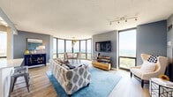 Located in Chicago's vibrant Lincoln Park neighborhood, this high-rise residence offers an impressive layout across two bedrooms, two bathrooms, and over 1,000 square feet of thoughtfully designed living space. Light wood flooring flows throughout, complemented by a neutral gray palette that creates a clean, modern aesthetic.

The combined living and dining area is the centerpiece of the home, featuring expansive floor-to-ceiling windows wrapping around a corner that frame sweeping panoramic views of Lake Michigan, Lincoln Park, and the Chicago skyline. Track lighting and open sightlines make the space feel bright and airy throughout the day.

The galley-style kitchen is well-appointed with white cabinetry, subway tile backsplash, stainless steel appliances, and a breakfast bar with industrial-style seating. A dedicated entrance hallway with ample closet space — five closets total — provides excellent storage throughout the unit.

The primary bedroom is generously sized, featuring corner windows with direct views of the Chicago skyline, flooding the room with natural light. The second bedroom similarly benefits from large windows with open city and treetop views. Both bathrooms are finished with clean, contemporary fixtures and tile work.

This residence combines functional layout with remarkable elevated views, making it a distinctive offering in one of Chicago's most sought-after neighborhoods.