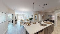 Located in E Courtland Estates in Mesa, Arizona, this single-story residence offers a thoughtfully designed open-concept layout that seamlessly connects the kitchen, dining, and living areas. Light wood-style flooring flows throughout, complementing the neutral color palette and creating a bright, cohesive atmosphere.

The kitchen is a standout feature, equipped with rich dark-toned cabinetry, a tile mosaic backsplash, stainless steel appliances, and a generous island with quartz countertops and pendant lighting—ideal for both cooking and casual dining. The island opens directly to the dining area, which is anchored by a round glass-top table and an elegant chandelier, and flows into the living room.

The living area is generously proportioned, featuring a ceiling fan, large sliding glass doors that invite abundant natural light and outdoor views, and ample space for comfortable seating arrangements.

The bedroom is a serene retreat with a ceiling fan, natural light from a well-placed window, and a refined, calming aesthetic. The en-suite bathroom impresses with a lengthy double-sink vanity topped with quartz, dark wood cabinetry, a glass-enclosed walk-in shower, and light wood-style flooring that ties the space together.

Overall, this residence delivers a polished, contemporary living experience in a well-located Mesa community.
