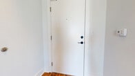 Located at 2100 Pickens St in Columbia, SC, this one-bedroom unit offers a well-organized layout across a single floor, encompassing a combined kitchen and living area, a private bedroom, a hallway, and a closet. Throughout the space, rich hardwood flooring adds warmth and character, with natural patina and texture that speak to the building's historic charm.

The kitchen is outfitted with white shaker-style cabinetry, stainless steel appliances including a range, microwave, dishwasher, and refrigerator, complemented by granite countertops and a classic subway tile backsplash. The open connection to the living area creates a functional and cohesive shared space.

The bedroom is a comfortable, well-proportioned room featuring the same hardwood floors, crisp white walls, and a window that brings in natural light. The high ceilings present throughout the unit enhance the sense of openness and airiness despite the efficient footprint.

A dedicated closet provides storage, while a hallway connects the rooms with ease. Notably, a stacked washer and dryer unit is conveniently housed within the space, adding a practical amenity. Windows throughout frame views of the surrounding brick architecture, grounding the unit in its Columbia neighborhood context.
