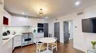 Located in the heart of West Hollywood, this thoughtfully designed one-bedroom, two-bathroom unit at 1267 N Laurel Avenue offers a modern aesthetic with high-quality finishes throughout. The open-concept layout maximizes every inch of the space, creating a seamless flow between the kitchen, dining, and living areas.

The kitchen is a standout feature, boasting sleek white flat-front cabinetry, a striking marble-effect backsplash, quartz countertops, a professional-grade stainless steel gas range, and built-in stacked appliances. A warm wood open-shelf cabinet adds an inviting contrast to the otherwise crisp, contemporary palette. Rich hardwood flooring runs throughout, anchoring the design with warmth and texture.

The living room is bright and airy, lined with large windows that offer views of the surrounding West Hollywood neighborhood and flood the space with natural light. A stylish sliding barn door provides privacy without sacrificing the open feel of the unit.

The bedroom is a calm retreat with clean white walls, a window with neighborhood views, and well-proportioned dimensions for comfortable living. Both bathrooms are finished with large-format marble-look tile, offering a clean, spa-inspired atmosphere. The unit combines functional design with modern elegance in a prime West Hollywood location.