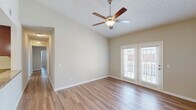 Located at 3220 Hoffmeyer Rd in Florence, South Carolina, this single-story, 3-bedroom, 2-bathroom home offers a well-designed layout across a comfortable footprint. Warm-toned hardwood-style flooring runs throughout, complemented by neutral beige walls and white trim that create a clean, cohesive aesthetic.

The living room is bright and airy, featuring vaulted ceilings, a ceiling fan with light fixture, and French doors that invite abundant natural light and outdoor views. The adjacent dining room continues the open feel, accented by crown molding and an elegant chandelier overhead. The galley-style kitchen is well-appointed with warm wood cabinetry, granite-look countertops, and black appliances including a refrigerator, range, and over-the-range microwave, alongside a textured ceiling for added character.

The spacious primary bedroom offers vaulted ceilings, a ceiling fan, a large window, and access to a generously sized walk-in closet with wire shelving systems. The two additional bedrooms are comfortably sized, each with ceiling fans and natural light. The bathrooms feature tub-shower combinations with brushed nickel fixtures. A dedicated laundry room includes upper cabinetry and washer/dryer hookups, adding everyday convenience to this well-rounded home.