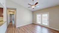 Located at 3220 Hoffmeyer Rd in Florence, South Carolina, this single-story, 3-bedroom, 2-bathroom home offers a well-designed layout across a comfortable footprint. Warm-toned hardwood-style flooring runs throughout, complemented by neutral beige walls and white trim that create a clean, cohesive aesthetic.

The living room is bright and airy, featuring vaulted ceilings, a ceiling fan with light fixture, and French doors that invite abundant natural light and outdoor views. The adjacent dining room continues the open feel, accented by crown molding and an elegant chandelier overhead. The galley-style kitchen is well-appointed with warm wood cabinetry, granite-look countertops, and black appliances including a refrigerator, range, and over-the-range microwave, alongside a textured ceiling for added character.

The spacious primary bedroom offers vaulted ceilings, a ceiling fan, a large window, and access to a generously sized walk-in closet with wire shelving systems. The two additional bedrooms are comfortably sized, each with ceiling fans and natural light. The bathrooms feature tub-shower combinations with brushed nickel fixtures. A dedicated laundry room includes upper cabinetry and washer/dryer hookups, adding everyday convenience to this well-rounded home.