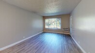 Located at 1390 Creekside Dr in Walnut Creek, California, this one-bedroom, one-bathroom unit offers a well-designed single-floor layout with a functional and comfortable living space. Wood-style flooring runs throughout the unit, lending a clean, cohesive look from room to room.

The kitchen is a standout feature, outfitted with white shaker cabinets, granite countertops, a stainless steel refrigerator, electric range, and dishwasher. A peninsula countertop opens directly into the combined dining and living area, creating an open, connected feel ideal for everyday living and entertaining. The living room receives natural light through a large window with views of surrounding greenery, and includes a ceiling fan for added comfort.

The bedroom is a generous size, featuring a sliding-door closet, hardwood-style flooring, and a window overlooking lush outdoor scenery. The bathroom is well-appointed with a white vanity, full tub/shower combo, and modern fixtures. Additional conveniences include an in-unit laundry area, a hallway connecting the main spaces, and a private patio. The unit also includes wall-mounted HVAC units in the living and bedroom areas.