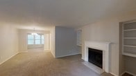 Located at 4601 Baymar Dr in Raleigh, North Carolina, this single-floor home offers a comfortable and functional layout designed for everyday living. The living area serves as the heart of the home, centered around a classic white-framed fireplace that adds warmth and character to the space. Adjacent to the fireplace, built-in shelving provides both practical storage and display options, seamlessly integrated into the wall for a clean, cohesive look. Soft, neutral-toned carpeting runs throughout, contributing to a warm and inviting ambiance. The living area flows naturally into the dining space, which is illuminated by a chandelier and benefits from natural light streaming through a large window. The neutral color palette — featuring soft grays and warm whites — creates a calming atmosphere throughout. The textured ceiling adds subtle visual interest, while the open-concept connection between the living and dining areas enhances the overall sense of space and makes the home well-suited for both relaxed daily living and casual entertaining.