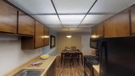 Located at 2601 N John B Dennis Hwy in Kingsport, Tennessee, this single-floor residence offers a well-organized layout designed for comfortable everyday living. The kitchen is outfitted with warm wood cabinetry, butcher block-style countertops, wood-look flooring, black appliances including a refrigerator, electric range, and over-the-range microwave, along with a double basin sink. The kitchen flows naturally into the dining area, which features wood-look flooring, a pendant light fixture, neutral blue-gray walls, and space for a full dining table and chairs. The living room is carpeted and offers a relaxed atmosphere with neutral warm-toned walls. The primary bedroom is carpeted and well-lit by a window, providing natural light, and includes ample space for a full bedroom suite. A second bedroom also features carpet flooring, a spacious sliding-door closet, and convenient access to the bathroom. The bathroom includes a wide vanity with a large mirror, a well-lit countertop, and a shower-tub combination. Throughout the residence, the consistent use of neutral tones, carpet in the sleeping areas, and wood-look flooring in the main living spaces creates a cohesive and functional interior.