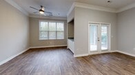 Located at 303 Cranbrook Dr in Asheville, NC, this well-appointed one-bedroom, one-bathroom residence offers a thoughtfully designed single-level layout. The open-concept kitchen and living area serves as the heart of the home, featuring hardwood-style flooring, crown molding, and generous natural light from multiple windows. A ceiling fan adds comfort to the living space, which also benefits from French door access to the outdoors. The kitchen is outfitted with crisp white cabinetry, granite countertops, stainless steel appliances including a gas range and refrigerator, and a peninsula that provides additional workspace and casual seating. A built-in cabinet nook with a granite surface in the living/dining area adds a distinctive architectural detail and extra storage. The hallway leads to a dedicated laundry closet housing a full-size washer and dryer. The spacious bedroom is finished with plush carpet, multiple windows offering views of the surrounding greenery, and a ceiling fan. The bathroom features a tiled tub-shower combination with a decorative accent tile border, granite vanity, and hardwood-style flooring. A dedicated closet completes this efficiently organized and well-finished residence.