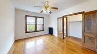 Located at 2256 N Cleveland Ave in Chicago's desirable Lincoln Park neighborhood, this single-floor unit offers a well-organized layout comprising a main living area, kitchen, bathroom, and closet. The main room is a standout, featuring warm hardwood floors that run throughout the space, a ceiling fan with integrated lighting, and double windows with rich dark wood trim that frame views of the surrounding neighborhood and invite generous natural light. A cast-iron radiator underscores the building's classic Chicago character. The kitchen is neatly defined by a dark wood archway and is equipped with oak cabinetry, white tile backsplash, a full-size refrigerator, a gas range, and a built-in sink — providing all essential cooking amenities in an efficient footprint. The walk-in closet offers full-length hanging rods and an overhead shelf, maximizing storage within the compact floor plan. The bathroom features a tiled shower-tub combination with a frosted window that allows natural light while maintaining privacy. Consistent hardwood flooring, white walls, and wood trim detailing throughout create a cohesive and classic aesthetic that reflects the timeless character of Lincoln Park architecture.