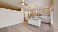 Located along Stone Oak Parkway in San Antonio, TX, this well-appointed single-floor, one-bedroom, one-bathroom residence offers a thoughtfully designed open-concept layout. The combined kitchen and living area serves as the heart of the home, featuring light wood-tone cabinetry, granite countertops, a marble-style tile backsplash, and a central kitchen island with an undermount sink and pendant lighting. Stainless steel appliances — including a range, microwave, and refrigerator — complement the modern aesthetic, while hardwood-style flooring and a ceiling fan add both style and comfort. Natural light fills the living area through multiple windows and a glass door that opens to the exterior. A clean, well-lit hallway connects the main living space to the private areas of the home, with a stacked Whirlpool washer and dryer conveniently located nearby. The bedroom is carpeted for warmth and comfort, with a ceiling fan overhead and direct access to the laundry area. The bathroom is finished with wood-look tile flooring, a granite-topped vanity with taupe cabinetry, and a tub-shower combination surrounded by elegant marble-style tile. A dedicated closet and utility room round out the functional layout of this efficiently designed residence.