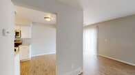 This two-floor residence offers a clean, functional layout with a neutral color palette throughout. The main living area is bright and open, benefiting from natural light that streams through large sliding glass doors fitted with vertical blinds, as well as an additional window — creating an airy, welcoming atmosphere. Wood-look luxury vinyl flooring runs throughout the main living and kitchen areas, adding warmth and continuity.

The galley-style kitchen is well-appointed with white shaker cabinetry, light granite-style countertops, a stainless steel sink, and a full suite of stainless steel appliances including a range, microwave, dishwasher, and refrigerator. A door at the end of the kitchen provides additional access to the exterior. A ceiling fan is positioned in the dining area adjacent to the kitchen, enhancing airflow through the space.

The bedrooms feature plush carpet flooring and are served by sliding double-door closets offering generous storage. The bathroom includes a full tub-shower combination with surrounding surround panels, a toilet, a vanity, white overhead cabinetry, and wood-look flooring. The overall ambiance of the space is practical and move-in ready, with a bright, neutral aesthetic throughout both floors.