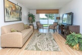 Located at 1703 Cresthill Ave in Royal Oak, Michigan, this single-floor residence offers a thoughtfully arranged layout with a cohesive design throughout. The living room serves as a central gathering space, featuring warm hardwood-style flooring, neutral walls, and a large sliding glass door that floods the room with natural light while providing direct access to the outdoors. The open sightlines and generous proportions make this area ideal for both relaxing and entertaining.

Adjacent to the living room, the dining area accommodates a compact dining set beneath a ceiling fan, with easy access to the galley-style kitchen. The kitchen is efficiently designed with white cabinetry lining both sides, ample counter space, hardwood-style flooring, and white appliances, creating a clean and functional workspace.

The bedrooms offer a comfortable retreat, with plush carpeting underfoot and good-sized windows that invite natural light. The primary bedroom features notable closet space, while the secondary bedroom also provides practical storage. The bathroom includes a full tub-shower combination, a vanity with storage, and tile flooring. Throughout the home, the consistent use of light tones and natural materials creates a calm, cohesive ambiance.
