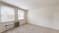 Located at 303 Holly Dr in Middle River, MD, this single-floor unit offers three bedrooms, one full bathroom, a kitchen, a hallway, and four closets. The layout is efficiently designed to maximize the available living space.

The bedrooms are carpeted and feature neutral, cream-toned walls with white trim. Each room benefits from natural light through multiple windows fitted with blinds, and classic cast-iron radiators provide supplemental heating. The spacious primary bedroom includes two closets, offering generous storage. The additional bedrooms are well-proportioned and also feature radiator heating and bright window views.

The kitchen is appointed with rich, warm-toned cabinetry, grey laminate countertops, and wood-look vinyl plank flooring. It is equipped with stainless steel appliances, including a range, microwave, and dishwasher, along with a window that brings in natural light.

The full bathroom includes a soaking tub with shower, toilet, and vanity sink, accented by wood-look tile flooring and a radiator. Windows in the bathroom provide ventilation and light.

The entry area features durable hard-surface flooring, a wall-mounted AC unit, and double windows overlooking the exterior neighborhood. Throughout, the space maintains a clean, functional character suited for comfortable everyday living.