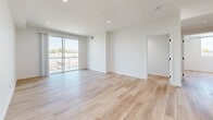 Located at 10934 Peach Grove St in North Hollywood, Los Angeles, this thoughtfully designed 2-bedroom, 2-bathroom residence offers a clean, modern aesthetic across a well-appointed single floor. Light wood-look flooring flows seamlessly throughout the entire space, complementing the crisp white walls and creating a bright, cohesive feel.

The open-concept living and dining area is generously proportioned, with recessed lighting and a sliding glass door that leads to a private balcony offering open views of the surrounding neighborhood and distant hills. The kitchen is well-equipped with white shaker cabinetry, white quartz countertops, stainless steel appliances including a gas range, over-the-range microwave, and dishwasher, along with a window that brings in natural light.

The spacious primary bedroom features a mirrored sliding closet and a private doorway, while the second bedroom benefits from dual windows with scenic outdoor views and its own closet. Both bathrooms are finished with large-format light tile flooring, white vanity cabinetry, and sleek glass sliding shower-tub enclosures with brushed nickel hardware. An in-unit laundry area adds everyday convenience to this modern, move-in-ready residence.