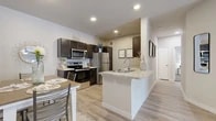 This thoughtfully designed 2-bedroom, 2-bathroom residence offers a functional single-floor layout that maximizes every square foot. The open-concept living, dining, and kitchen area serves as the heart of the home, featuring light wood-look flooring, neutral toned walls, and a ceiling fan that enhances the airy atmosphere. The living room receives natural light through sliding glass doors and large windows, creating a bright and welcoming space.

The kitchen is equipped with stainless steel appliances, including a refrigerator, electric range, and built-in microwave, all complemented by rich dark cabinetry and granite-style countertops. A peninsula with an undermount sink and additional counter space flows seamlessly into the adjacent dining area, making it ideal for both cooking and entertaining.

Each bedroom features plush carpeting, ceiling fans, and ample natural light from well-positioned windows. The primary bedroom offers generous proportions and comfortable finishes. Both bathrooms are finished with dark wood vanities, granite-style countertops, large mirrors, and tiled tub-shower combinations set on wood-look flooring. A dedicated closet provides practical storage. Recessed lighting and consistent finishes throughout give the home a cohesive, modern aesthetic.
