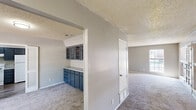 Located at 2701 Southwest Drive in Abilene, Texas, this single-story, 3-bedroom, 2-bathroom home offers a thoughtfully arranged floor plan with a comfortable sense of space throughout. Textured ceilings are a consistent architectural detail found across the home, lending a classic character to each room.

The kitchen features dark navy-blue lower cabinetry paired with upper dark cabinets, light countertops, a double sink, and wood-look vinyl plank flooring. White appliances including a refrigerator and dishwasher are included, and a window above the sink brings in natural light. An adjacent built-in cabinetry area with glass-front upper cabinets and matching blue lower drawers provides additional storage and counter space, set against wainscoting-style wall paneling.

The spacious living room is carpeted and features a ceiling fan, a glass-panel door, and windows that welcome outdoor views and natural light. The generously sized primary bedroom also features plush carpeting, a ceiling fan, and a bright window with outdoor views. The two bathrooms are well-appointed — one features wood-look vinyl plank flooring, a long vanity with ample counter space and a wide mirror, while the other includes a full tub-shower combination with clean white tile surround. A hallway and two closets round out this practical and comfortable home.