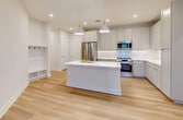 This contemporary apartment offers 1040 square feet of thoughtfully designed living space. The open-concept floor plan showcases a gourmet kitchen with sleek white cabinetry, stainless steel appliances, and a central island, perfect for entertaining. The living area is bathed in natural light from large windows, creating a bright and airy atmosphere.

The two bedrooms are generously sized, with the primary bedroom boasting 180 square feet of space. Each bedroom features ceiling fans and ample closet space with custom organization systems. The three bathrooms are elegantly appointed with modern fixtures and finishes.

Throughout the apartment, you'll find high-quality wood-look flooring that adds warmth and durability. The neutral color palette provides a versatile backdrop for any decor style. Additional features include recessed lighting, window blinds for privacy, and a convenient in-unit laundry area.

This well-designed space maximizes functionality without compromising on style, offering a perfect blend of comfort and modern urban living in the heart of Tampa.