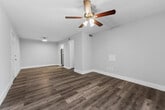 This thoughtfully designed 2-bedroom, 2-bathroom residence in Birmingham, Alabama offers a clean, modern aesthetic throughout its single-story layout. Consistent wood-look plank flooring in a cool gray tone flows seamlessly through the living areas and bedrooms, complemented by soft gray walls and crisp white trim that create a bright, cohesive atmosphere.

The living room is a comfortable, open space anchored by a ceiling fan with light fixture and a sliding glass door dressed with vertical blinds, allowing natural light to fill the room. The galley-style kitchen has been attractively updated with white shaker cabinetry, gray countertops, a classic white subway tile backsplash, and a full suite of stainless steel appliances including a range, microwave, refrigerator, and dishwasher.

Both bedrooms are well-proportioned, with the primary bedroom offering generous space, a ceiling fan, and its own access to closets. The second bedroom features a window with natural outdoor views. Each room provides ample closet storage, supported by three closets total throughout the unit.

The two bathrooms are finished with elegant marble-look tile flooring, white vanity cabinetry with dark countertops, and tub-shower combinations. Additional conveniences include a dedicated laundry area and a utility room, rounding out this move-in-ready Birmingham residence.