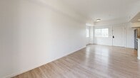 Located at 177 N Myrtle Ave in Pomona, CA, this well-appointed 2-bedroom, 2-bathroom single-floor unit offers a clean, modern aesthetic throughout. The open-concept living area seamlessly connects the kitchen, dining, and living spaces, all finished with light wood-style flooring and crisp white walls that maximize brightness. Large sliding glass doors in the living room lead to a private balcony, filling the space with natural light and offering outdoor views.

The kitchen is thoughtfully designed with granite countertops, white shaker-style cabinetry, a peninsula with a double sink, and a full suite of stainless steel appliances including a refrigerator, range, microwave, and dishwasher. Recessed lighting adds a polished finish to this functional cooking space.

The spacious primary bedroom features arched windows that allow ample natural light, along with a dedicated closet with built-in shelving. The second bedroom also benefits from arched windows and generous proportions. Both bathrooms mirror the home's refined style, featuring granite vanity tops, white cabinetry, and a shower-tub combination with sliding glass doors. Additional highlights include three closets, a laundry area, a utility room, and a connecting hallway that ties the layout together efficiently.