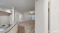 Located at 190 Golf Course Dr in Rohnert Park, California, this well-appointed 2-bedroom, 2-bathroom residence offers a comfortable and functional single-floor layout. The open-concept living and kitchen area forms the heart of the home, featuring vaulted ceilings with a ceiling fan, plush neutral-toned carpeting, and a window with vertical blinds that allows for natural light. Crown molding adds an elegant touch to the primary bedroom, which is generously sized and includes a walk-in closet outfitted with wire shelving on both sides for organized storage. The second bedroom is equally well-proportioned, with carpeted floors and a window fitted with blinds. The kitchen is equipped with stainless steel appliances, including a refrigerator, range, and microwave, complemented by white cabinetry, stone-look countertops, and a peninsula with a sink that opens to the living area. Both bathrooms are finished in clean white tones with vanity storage and large mirrors. A dedicated in-unit laundry room houses a full-size side-by-side washer and dryer beneath ample upper cabinetry. The overall ambiance is bright, neutral, and move-in ready.