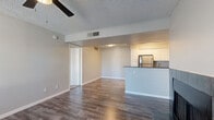 This single-floor residence offers a thoughtfully designed layout that balances open communal spaces with comfortable private quarters. The living area is a welcoming focal point, featuring rich wood-look flooring, a ceiling fan, a textured ceiling, and a tile-surround fireplace that anchors the room. A large window allows natural light to fill the space, creating a bright and airy atmosphere.

The kitchen is efficiently designed with white shaker-style cabinetry, dark granite countertops, a breakfast bar peninsula, and a full suite of stainless steel appliances including a refrigerator, range, and microwave. Wood-look flooring continues seamlessly from the living area into the kitchen, reinforcing the cohesive open-plan feel.

The bedrooms are carpeted for comfort and equipped with ceiling fans and windows that bring in natural light. Each room offers a calm, neutral palette well-suited for rest and relaxation.

Both bathrooms are finished with white cabinetry, dark granite vanity countertops, and wood-look flooring. One bathroom features a tub-shower combination, while both include large mirrors and ample under-sink storage. The overall design throughout the unit is clean and contemporary, with neutral gray tones, white trim, and modern fixtures providing a polished, move-in-ready aesthetic.