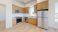 Located at 910 20th St in Bakersfield, CA, this 2-bedroom, 1-bathroom unit offers a thoughtfully designed layout with a clean, contemporary aesthetic throughout. Light wood-tone luxury vinyl flooring runs continuously across all rooms, complementing the crisp white walls and creating a bright, cohesive feel.

The kitchen is well-equipped with warm wood cabinetry, stainless steel appliances including a range, microwave, dishwasher, and refrigerator, along with light countertops and a window that brings in natural light. The open flow from the kitchen through the hallways connects the space efficiently.

Both bedrooms are comfortably sized, each featuring large windows that invite natural light and provide outdoor views of the surrounding neighborhood. The primary bedroom includes a dedicated walk-in closet with a built-in shelving rod, and a wall-mounted mini-split HVAC unit for individual climate control. The second bedroom similarly benefits from a wall-mounted HVAC unit.

The bathroom features a dual-sink vanity with warm wood cabinetry, matte black fixtures, and large mirrors above each sink, offering both functionality and a refined finish. Recessed lighting throughout the unit adds to the clean, modern atmosphere, making this a well-appointed and move-in ready space.