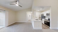 Located at 2351 Pine Brook Dr in Kissimmee, FL, this one-bedroom, one-bathroom unit offers a well-designed single-floor layout with a cohesive, neutral color palette throughout. The open living room is bright and welcoming, featuring plush carpeting, a ceiling fan, and sliding glass doors that lead to a private balcony with outdoor views — filling the space with natural light. A pass-through peninsula counter connects the living area to the kitchen, which is thoughtfully designed with white shaker-style cabinetry, white quartz countertops, a stainless steel sink, and stainless steel appliances including a refrigerator, range, microwave, and dishwasher, all set over light wood-look flooring. The bedroom is generously sized with two large windows that invite abundant natural light, soft carpeting, a ceiling fan, and access to a dedicated walk-in closet. The full bathroom features a tiled tub-shower combination with brushed nickel fixtures, a white vanity, and wood-look flooring. A dedicated laundry area with a full-size washer hookup adds everyday convenience. Clean finishes, practical storage, and a functional layout make this unit a comfortable and efficient home.