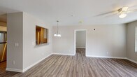 Located at 4208 Legacy Park Way in Ayden, NC, this single-story home offers a cohesive, modern interior defined by wood-look flooring that flows consistently throughout every room. Neutral, warm-toned walls create a clean and welcoming atmosphere across the entire floor plan.

The kitchen is well-equipped with white cabinetry, granite-style countertops, stainless steel appliances including a refrigerator, range, and built-in microwave, and a convenient pass-through window that connects to the adjacent dining area. A pendant light fixture accents the dining space, adding a touch of character.

The living areas are generously sized, each featuring ceiling fans and windows dressed with white blinds that allow natural light to filter through. Multiple bedrooms provide comfortable accommodations, with at least one room offering direct access to a walk-in closet and an en suite bathroom. The bathrooms are finished with cream-toned vanities, light stone countertops, and a tub-shower combination, all accented by brushed nickel hardware. The overall design is functional, clean, and move-in ready.