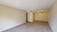 This two-bedroom, one-bathroom apartment at 1000 Darbyshire Rd in Lyndon, KY offers a well-organized single-floor layout designed for comfortable everyday living. The living room is generously sized, featuring warm neutral-toned walls, soft carpeting, a ceiling fan with light fixture, and a sliding glass door that opens to a private outdoor balcony, allowing natural light to fill the space. The kitchen is equipped with white cabinetry accented by dark wood trim, a coil-top electric range, an overhead ventilation hood, ample counter space, and a stainless steel sink, all set on wood-look flooring. The primary bedroom is a comfortable size, featuring carpeted floors, a closet, and a window that brings in natural light. The second bedroom also offers carpeted flooring, bright windows with blinds, and a closet for storage. The full bathroom includes a tub-shower combination with chrome fixtures and tile flooring. Additional spaces include a utility room and a dedicated closet. Throughout the unit, a consistent palette of light beige walls and neutral carpeting creates a clean, cohesive atmosphere suited for a variety of living arrangements.