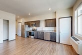 Located on the fourth floor at 315 N Worthen St in Wenatchee, WA, this efficiently designed studio offers a thoughtful layout that maximizes every square foot of its single-floor plan. Light-toned hardwood-style flooring runs throughout, lending warmth and visual continuity across the entire space.

The kitchen is a standout feature, outfitted with rich dark-stained cabinetry, light quartz-style countertops, a mosaic tile backsplash, and a full suite of stainless steel appliances including a refrigerator, electric range, microwave, and dishwasher. The kitchen flows openly into the main living area, creating a cohesive and functional living space.

The living area is bright and airy, benefiting from large windows that frame scenic mountain views of the surrounding Wenatchee valley — a striking and distinctive feature of this unit. A wall-mounted HVAC unit ensures year-round comfort.

A spacious sliding-door closet provides ample storage directly within the main room. The bathroom is well-appointed with dark cabinetry and includes a dedicated in-unit laundry area with a stacked washer and dryer, adding significant convenience. Clean white walls and recessed lighting throughout contribute to a modern, move-in-ready aesthetic.