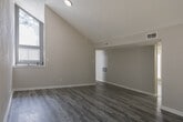 Located in Houston, TX 77090, this single-floor unit offers a thoughtfully updated interior with a clean, neutral aesthetic throughout. Durable wood-look plank flooring extends across all living areas, complemented by crisp white baseboards and soft gray walls that create a bright, cohesive feel.

The living area features soaring vaulted ceilings and a sliding glass door dressed with vertical blinds, allowing generous natural light to fill the space. A ceiling fan with a built-in light fixture adds both comfort and function. Adjacent to the living area, the kitchen is well-equipped with white cabinetry, white quartz countertops, a classic subway tile backsplash, a stainless steel undermount sink, and a full suite of appliances including an electric range, over-the-range microwave, and stainless steel refrigerator.

The bedrooms are generously proportioned, with multiple windows fitted with horizontal blinds providing ample natural light. One bedroom features a vaulted ceiling that adds a sense of openness, while another includes a closet with a rod and open shelving. The bathroom is fitted with a full tub-and-shower combination, white vanity cabinetry, and matching wood-look flooring.

A dedicated in-unit laundry area accommodates a full-size washer and dryer, adding everyday convenience to this move-in-ready Houston home.