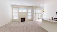 Located at 47305 Central Park Blvd in Novi, Michigan, this two-story residence offers a well-designed layout with a bright, open feel throughout. The living room serves as a central gathering space, highlighted by soaring double-height windows that flood the room with natural light and a tile-surround fireplace that adds a classic focal point. Soft carpeting runs through the living areas and bedrooms, while the adjacent dining area features warm hardwood-style flooring and an elegant chandelier overhead. The galley-style kitchen is well-equipped with stainless steel appliances, including a range, microwave, refrigerator, and dishwasher, complemented by white cabinetry and light countertops that extend to a convenient peninsula. A dedicated laundry area houses a full-size washer and dryer. The space includes two full bathrooms — one with a glass-enclosed walk-in shower and another with a soaking tub and shower combination — both finished with tile flooring and white vanity cabinetry. Bedrooms are carpeted and offer natural light through window treatments. The attached garage provides secure parking and additional storage. The overall aesthetic is clean, neutral, and move-in ready, offering a comfortable and functional living environment in a desirable Novi location.