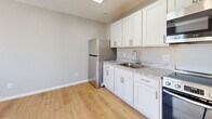 Located at 600 Sherman St in Akron, Ohio, this efficiently designed one-bedroom, one-bathroom unit offers a clean, modern aesthetic throughout its single floor. The interior is unified by warm light hardwood flooring and soft gray walls, creating a bright and cohesive living environment.

The kitchen is a standout feature, outfitted with white shaker-style cabinetry, granite-look countertops, and a full suite of stainless steel appliances including a refrigerator, electric range, over-the-range microwave, and dishwasher. A stainless steel sink and ample upper and lower cabinet storage round out this well-appointed space.

The bedroom is a comfortable, well-lit room featuring a sliding closet for storage, natural light from a double-hung window, and the same hardwood flooring found throughout the unit. The textured ceiling adds a subtle architectural detail to the space.

The bathroom is clean and functional, featuring a full tub-shower combination with a white surround, chrome fixtures, and hardwood-style flooring that ties into the rest of the home.

Overall, this unit presents a freshly updated interior with consistent finishes, making it a practical and attractive space in the Akron area.