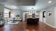 Located in the heart of downtown Cleveland at 526 E Superior Ave, this single-floor residence combines modern finishes with an urban setting. The open-concept living and kitchen area serves as the centerpiece, featuring rich hardwood flooring that flows throughout the main living spaces. The kitchen is well-appointed with white shaker cabinetry, granite countertops, stainless steel appliances, a mosaic tile backsplash, and a dark-finished island with seating — ideal for both casual dining and entertaining.

The living area benefits from large, dark-trimmed windows that frame striking views of Cleveland's surrounding architecture, allowing natural light to fill the space. A secondary sitting area provides additional flexibility for relaxing or working.

The bedroom is a comfortable retreat, finished with plush carpeting, a ceiling fan, and a generous window with city views. The bathroom features elegant granite countertops, white cabinetry with brushed nickel hardware, tile flooring, and a large dark-framed mirror, offering a clean and refined aesthetic.

Throughout the residence, neutral gray and taupe tones create a cohesive, contemporary atmosphere, complemented by quality finishes that reflect the character of this vibrant downtown Cleveland location.