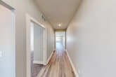 Located at 3879 Lone Pine Dr in Holt, Michigan, this two-story home offers a thoughtfully designed layout spread across two well-proportioned floors. The main level features an open and airy living area with luxury vinyl plank flooring, recessed lighting, and a striking barn door accent. The modern kitchen is a standout, showcasing white shaker cabinetry, a subway tile backsplash, stainless steel appliances, a large center island with an undermount sink, and pendant lighting — all complemented by large windows that invite abundant natural light. A dedicated pantry provides excellent storage. The main level also includes a laundry room equipped with a full-size washer and dryer. Upstairs, light-toned hallways with hardwood-style flooring connect three spacious bedrooms, each featuring plush carpet and neutral wall tones. The generously sized primary bedroom offers a comfortable retreat. Three full bathrooms are distributed throughout the home, including tub-shower combinations with brushed nickel fixtures. Additional highlights include multiple closets, two staircases, an attached garage, and an unfinished basement with rough-in plumbing — providing excellent potential for future expansion. The home's clean, contemporary aesthetic and practical layout make it an ideal residence in the Holt community.