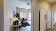 This single-floor residence offers a thoughtfully designed open-concept layout that seamlessly connects the kitchen, dining, and living areas. The living room is bright and welcoming, featuring vaulted ceilings, a ceiling fan, and multiple windows dressed with blinds and white curtains that invite generous natural light. Wood-look flooring runs throughout the main living spaces, lending a warm, cohesive aesthetic.

The kitchen is well-equipped with white shaker-style cabinetry, granite-look countertops, and a full suite of stainless steel appliances including a refrigerator, range, microwave, and dishwasher. Ample counter space and storage make it highly functional for everyday use.

The bedroom is a standout feature, showcasing a dramatic navy accent wall paired with neutral tones on the remaining walls. The room accommodates a generously sized bed and includes a closet with sliding doors, as well as a window that allows natural light to filter in through blinds and white draping curtains.

The bathroom is clean and modern, featuring white cabinetry with brushed nickel hardware, a granite-look countertop with an undermount sink, a large vanity mirror, and wood-look tile flooring. A window provides natural ventilation and light. Throughout the residence, a cohesive navy and neutral color palette creates a stylish, contemporary ambiance.