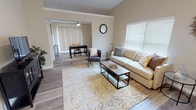 This single-floor residence offers a thoughtfully designed layout that balances comfort and functionality throughout. The open-concept living area features vaulted ceilings, warm-toned walls, and durable wood-look flooring that flows seamlessly from room to room. Natural light pours in through large windows fitted with horizontal blinds, creating a bright and welcoming atmosphere. The living space connects to a versatile flex area that can serve as a home office or dining space, complete with a ceiling fan overhead.

The kitchen is well-equipped with stainless steel appliances — including a refrigerator, range, microwave, and dishwasher — complemented by crisp white shaker-style cabinetry, granite-look countertops, and recessed lighting. A private entry door provides convenient exterior access directly from the kitchen area.

The residence includes multiple carpeted bedrooms, each featuring ceiling fans with light fixtures and ample natural light from well-placed windows. The primary bathroom is generously sized, offering a double-sink vanity with granite-look countertops, white cabinetry, wood-look flooring, and a shower-tub combination. A spacious walk-in closet with dual wire shelving and hanging rods provides abundant storage. Throughout, neutral tones and consistent finishes create a cohesive and move-in-ready living environment.