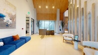 This leasing center and amenities facility in Round Rock, Texas, offers an expansive, thoughtfully designed space across a single floor. The grand lobby immediately impresses with soaring ceilings clad in warm wood paneling, large-format tile flooring, floor-to-ceiling windows, and a central reception desk flanked by curated seating areas and potted olive trees that lend a refined, welcoming atmosphere.

The fitness center is a standout amenity, boasting cathedral-height wood ceilings, abundant natural light from oversized windows with outdoor views, and a comprehensive selection of cardio equipment including treadmills, ellipticals, and stair climbers. A dedicated strength training zone features a full dumbbell rack with floor-to-ceiling mirrors, functional training equipment, and a turf runner for dynamic workouts.

The social lounge and game room features a ping-pong table, billiards table, large-screen TV with lounge seating, and a stylish wet bar accented by a sculptural wood slat partition draped with greenery. A dedicated dining and conference room showcases a stunning live-edge wood table, modern pendant lighting, and floor-to-ceiling windows overlooking an outdoor courtyard. Private office spaces with glass-paneled doors complete this well-appointed facility, designed to serve both community and professional needs.