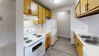 Located at 2714 S Emporia St in Wichita, Kansas, this one-bedroom, one-bathroom unit offers a practical and efficiently organized single-floor layout. The kitchen is well-appointed with warm oak-toned cabinetry offering ample upper and lower storage, a white electric range with overhead ventilation, a full-size refrigerator, and a sink with additional counter space along the opposing wall. Wood-look vinyl flooring runs throughout the kitchen, providing a clean and durable surface. The open living area flows naturally from the kitchen and features neutral-toned carpet underfoot, creating a comfortable and cohesive space. The bedroom is a well-proportioned retreat, finished with the same plush carpeting and a textured ceiling. A window allows natural light to brighten the room, while a closet provides convenient built-in storage. A dedicated laundry area with hookups and overhead shelving adds everyday practicality to the unit. Throughout the space, neutral wall tones, textured ceilings, and consistent flooring materials contribute to a clean, understated aesthetic that is easy to personalize.
