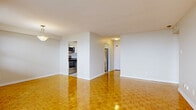 Located on Richmond Road in Ottawa, this one-bedroom, one-bathroom unit offers a well-organized layout across a single floor. Warm parquet flooring flows consistently throughout the living room, bedroom, and hallway, lending a classic and cohesive aesthetic to the space.

The bright living room is a standout feature, boasting floor-to-ceiling windows and a sliding glass door that opens onto a private balcony, flooding the room with natural light and providing open views of the surrounding cityscape. A pendant light fixture adds a refined finishing touch to this inviting area.

The kitchen is efficiently designed with white cabinetry, a white subway tile backsplash, and a full suite of stainless steel appliances including an electric range, built-in microwave, and dishwasher. Light tile flooring completes the clean, functional look.

The bedroom is a comfortable size, featuring parquet flooring, a ceiling fan, a window with outdoor views, and a sliding double-door closet for ample storage. The bathroom is finished with clean white subway tile in the tub surround, complemented by neutral wall tile accents and wood-look flooring. A hallway connects all rooms, completing this practical and well-appointed layout.