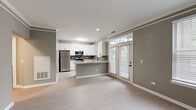 Located at 2800 Pontiac Drive in Aurora, Illinois, this single-floor, one-bedroom, one-bathroom residence offers a thoughtfully designed layout with modern finishes throughout. Light-toned luxury vinyl plank flooring and neutral gray walls create a clean, cohesive aesthetic across all rooms.

The kitchen is a standout feature, showcasing white shaker-style cabinetry, gray subway tile backsplash, and a granite peninsula with ample counter space. Stainless steel appliances — including a gas range, built-in microwave, and full-size refrigerator — complete the contemporary look. A window above the sink allows natural light to fill the space.

The adjacent hallway connects to a dedicated utility area, visible through an open doorway, which includes an in-unit washer and dryer. This practical addition enhances the overall functionality of the home.

The bedroom offers a comfortable, well-proportioned retreat with neutral gray walls, light flooring, and a large window fitted with horizontal blinds that frame a lush outdoor view, bringing in generous natural light.

The bathroom features a clean, modern design with a full tub-and-shower combination, white tile surround, and matte black fixtures that add a contemporary accent against the neutral backdrop.

A closet and hallway round out this efficient and well-organized home, making it an ideal space for comfortable everyday living.