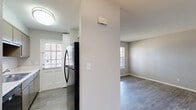 Located at 16 Beech Rd SE in Marietta, Georgia, this single-story, one-bedroom, one-bathroom home offers a practical and well-organized layout across a compact footprint. The living room greets you at entry with durable wood-look plank flooring, neutral gray walls, a textured ceiling, and a large window fitted with blinds that invites ample natural light into the space. The kitchen runs in a galley-style configuration, featuring gray cabinetry, a stainless steel refrigerator, a built-in sink, and a window-lit exterior door that adds both brightness and ventilation. The kitchen flows naturally into the main living areas, making everyday use efficient. The bedroom is carpeted for comfort and includes a generously sized dual-closet setup with bifold doors, providing excellent storage capacity. A ceiling fan overhead and a large window overlooking greenery contribute to a relaxed, airy atmosphere. The bathroom is straightforward and clean, offering a full tub-shower combo with white tile surround, chrome fixtures, and a small window for natural ventilation. Throughout the home, a consistent neutral color palette and clean finishes create a cohesive, move-in-ready feel suited for comfortable everyday living.