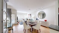 Located in Leawood, KS, this well-designed one-bedroom, two-bathroom residence offers a thoughtfully organized single-floor layout that maximizes every square foot. The open-concept living and dining area is bright and welcoming, featuring warm hardwood-style flooring, track lighting, and large windows that invite abundant natural light. A round dining table anchors the dining space, while the living room offers generous seating and a relaxed, contemporary ambiance.

The kitchen is a functional highlight, showcasing rich cherry wood cabinetry, dark granite countertops, a breakfast bar peninsula, stainless steel appliances, tile backsplash, and pendant lighting — ideal for both everyday cooking and entertaining.

The spacious primary bedroom features plush carpeting, a ceiling fan, and ample natural light from well-placed windows. A generous walk-in closet with built-in shelving and hanging rods provides excellent storage. The primary bathroom is finished with large-format floor tiles, a soaking tub, a glass-enclosed shower area, granite vanity, and warm neutral tones. A second full bathroom offers additional convenience for guests.

Throughout the residence, clean white walls, consistent finishes, and a neutral palette create a cohesive, modern aesthetic that is both inviting and refined.