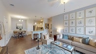 Located at 4140 Bayswater Rd in Winterville, NC, this single-story residence offers a cohesive, open-concept floor plan designed for comfortable everyday living. Rich hardwood-style flooring flows throughout the main living areas, anchoring the home's warm yet contemporary aesthetic.

The living room serves as the heart of the home, featuring soft blue-gray walls, a ceiling fan, and a large window with access to natural light. The space connects seamlessly to a dedicated dining area, which features classic wainscoting panels, a chandelier overhead, and hardwood-style flooring — offering an intimate setting for meals.

The kitchen is outfitted with white shaker-style cabinetry, granite countertops, and a full suite of stainless steel appliances, including a refrigerator, range, and microwave. A peninsula with seating provides additional workspace and casual dining options.

The bedroom is a serene retreat finished with plush carpet, natural light from large windows, and direct access to a walk-in closet. An additional flexible room serves well as a den or home office. Both bathrooms include white cabinetry, granite countertops, and tub-shower combinations with hardwood-style flooring, offering clean, functional design throughout.