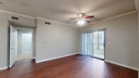 Located at 8383 El Mundo St in Houston, TX, this one-bedroom, one-bathroom unit offers a well-organized single-floor layout. The open living room is immediately welcoming, featuring vaulted ceilings that lend a sense of spaciousness, soft carpeting, and a ceiling fan with light fixture. A sliding glass door fitted with vertical blinds allows abundant natural light to pour in while providing access to an outdoor view. An elegant arched doorway connects the living area to the rest of the unit. The galley-style kitchen is efficiently designed with rich, dark wood cabinetry lining both sides, granite-look countertops, tile flooring, stainless steel appliances including a refrigerator, gas range, and built-in microwave, along with a double basin sink. A dedicated laundry area with washer and dryer hookups adds everyday convenience. The bedroom is a comfortable retreat with plush carpet, a ceiling fan, and a charming arched window that frames natural light beautifully. The bathroom is well-appointed with a wide vanity featuring granite-look counters, rich wood cabinetry, a large mirror, tile flooring, and a full tub-shower combination with tile surround. A closet and hallway complete the thoughtful layout of this Houston unit.