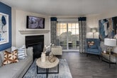 Located at 519 Morrell Rd in Knoxville, Tennessee, this single-floor residence offers a thoughtfully designed layout with comfortable living spaces throughout. The living room serves as the centerpiece of the home, anchored by a classic fireplace with a white mantel and a bold navy blue accent wall adorned with contemporary artwork. Dark hardwood-style flooring and an open sightline to the dining area contribute to the space's cohesive flow.

The kitchen is outfitted with white shaker-style cabinetry, granite countertops, a subway tile backsplash, and stainless steel appliances including a range, microwave, and dishwasher — delivering both style and functionality.

The primary bedroom features plush carpeting, a striking teal accent wall, large windows with blinds and drape panels, and ample room for a full furniture arrangement. A second bedroom mirrors this comfortable aesthetic with its own accent wall, a closet with bi-fold doors, and soft carpeted floors. Each bedroom is served by its own well-appointed bathroom — one featuring a full tub/shower combination with wood-look tile flooring, and the other offering a granite-topped vanity and tile flooring. The overall design palette of blues, grays, and neutrals creates a calm, modern ambiance throughout.