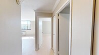 Located at 360 Main St in Hartford, CT, this one-bedroom, one-bathroom residence offers a well-organized single-floor layout designed to maximize every square foot. The space is finished with light hardwood-style flooring, crown molding, and a neutral warm-gray color palette throughout, creating a clean and cohesive aesthetic.

The kitchen is a standout feature, outfitted with sleek gray flat-front cabinetry extending to the ceiling, dark countertops, a stainless steel sink, a built-in oven, microwave, refrigerator, and a conveniently integrated in-unit washer. A central island provides additional prep and dining surface area.

The bedroom is a comfortably sized, sun-filled room featuring a large window with city views, light-toned flooring, crown molding, and a built-in closet with sliding doors. A second closet is also available within the unit for additional storage.

The bathroom is modern and refined, featuring a wall-mounted floating vanity with an integrated sink, a framed medicine cabinet mirror, and a full glass-enclosed walk-in shower with large-format tile surround and built-in shelving. Black matte hardware accents add a contemporary touch.

A hallway connects all rooms efficiently, with the open layout visible from the entry. The unit receives generous natural light, contributing to its bright and airy atmosphere.