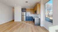 Located at 1722 Grove St in Denver's 80204 neighborhood, this modern two-bedroom, two-bathroom residence offers a thoughtfully designed single-level layout with clean, contemporary finishes throughout. Light wood flooring flows seamlessly across every room, complementing the crisp white walls and creating a bright, cohesive aesthetic.

The kitchen is a standout feature, showcasing a two-tone cabinetry design with warm natural wood upper cabinets and dark lower cabinets, accented by a white tile backsplash and a full suite of stainless steel appliances. The open layout connects the kitchen to the living area, making the space feel open and functional.

A clean, well-lit hallway with sliding closet doors leads to the two bedrooms, each featuring large windows that invite natural light and neighborhood views. Both bedrooms are equipped with wall-mounted mini-split HVAC units for individual climate control. Three closets provide ample storage throughout.

The two bathrooms reflect the same modern sensibility: one features a glass-enclosed walk-in shower with matte black fixtures and a floating vanity, while the second offers a full soaking tub with the same sleek hardware and finishes. In-unit laundry and a private balcony round out this well-appointed Denver residence.