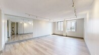 Located at 1 Gold St in downtown Hartford, CT, this well-appointed one-bedroom, one-bathroom residence offers a thoughtfully designed layout across a single floor. Light-toned hardwood flooring flows throughout the main living areas, complementing the neutral warm-gray palette that gives the space a clean, contemporary feel.

The living room is generously proportioned, featuring track lighting that provides flexible illumination and large windows offering open views of the Hartford skyline. Mirrored closet doors further enhance the sense of brightness and space. The bedroom is a comfortable retreat, also equipped with track lighting, mirrored closet doors, and its own window with city views, allowing ample natural light.

The galley-style kitchen is efficiently designed with slate-blue cabinetry, granite countertops, a mosaic tile backsplash, and stainless steel appliances including a gas range and refrigerator. White tile flooring completes the clean aesthetic.

The bathroom showcases elegant floor-to-ceiling marble-look tile surrounding a soaking tub with an overhead shower, complemented by built-in niche shelving and a large mirror above the vanity. Hallways connect all areas with ease. A textured ceiling adds a classic architectural touch throughout the residence.