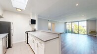Located at 909 Palm Ave in the heart of West Hollywood, this well-appointed 3-bedroom, 2-bathroom residence offers a thoughtfully designed single-floor layout with modern finishes throughout. The open-concept kitchen and living area serves as the heart of the home, featuring a galley-style kitchen outfitted with white shaker cabinetry, stone-look countertops, stainless steel appliances including a gas range and refrigerator, and a skylight that floods the space with natural light. A peninsula counter transitions seamlessly into the open living area, which is finished with wood-style flooring and crown molding. Floor-to-ceiling sliding glass doors lead to a private balcony overlooking lush palm trees and greenery, bringing a quintessential Southern California ambiance indoors. The three bedrooms are finished with the same wood-style flooring and crown molding, each offering natural light through well-placed windows. The primary bedroom is generously sized, while the additional bedrooms provide flexibility for various needs. Two closets offer practical storage solutions. The bathrooms are finished in a clean, bright aesthetic, with the full bath featuring subway tile, a tub-shower combination, and tile flooring. A hallway connects the private and shared spaces efficiently, completing this functional and attractive West Hollywood residence.